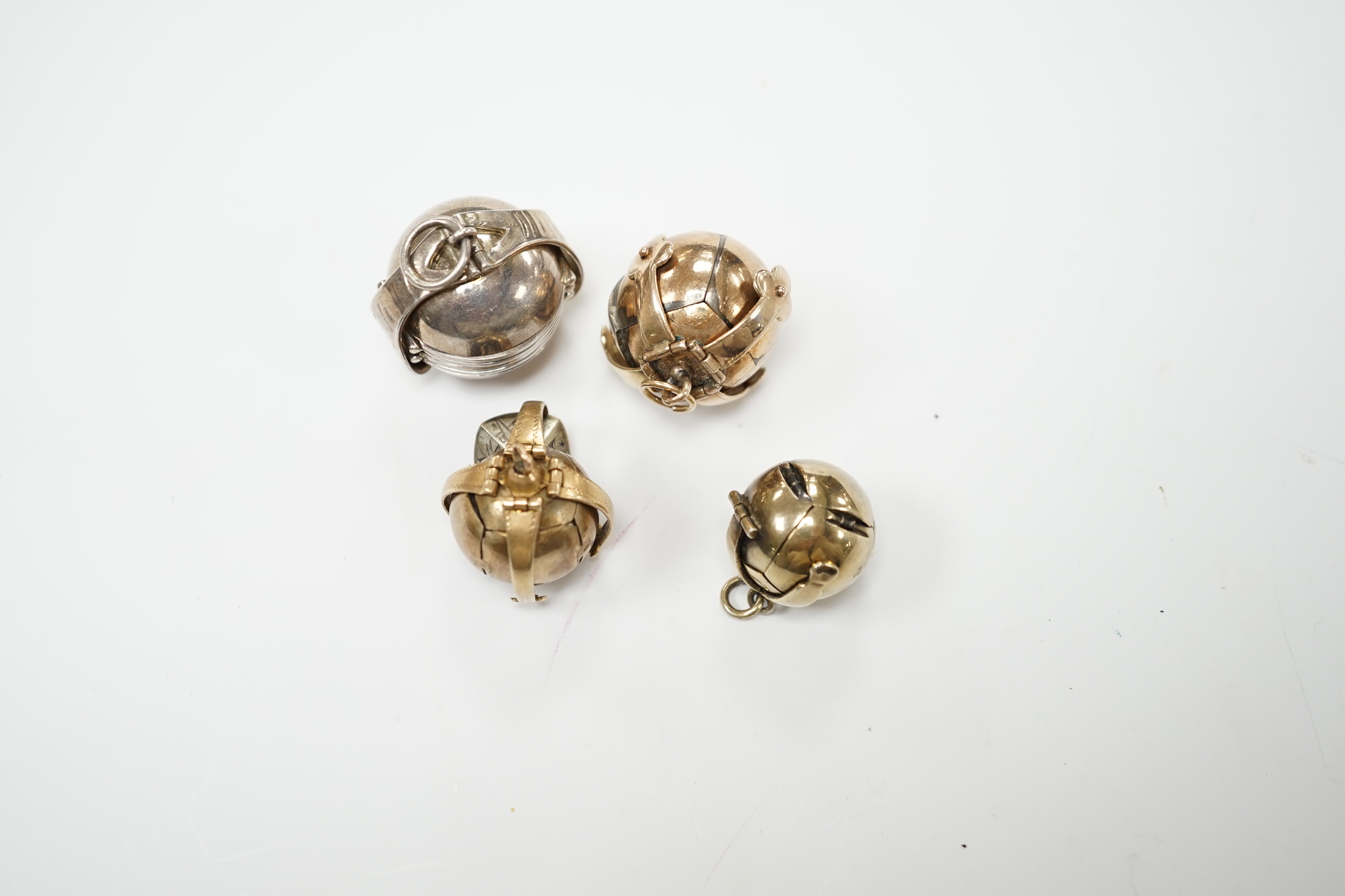 Three assorted masonic ball charms, one stamped 9ct and one other folding ball charm, largest 25mm.